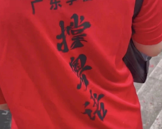 广东端午节扒龙船现场，有人穿撑粤语文化衫出来宣传